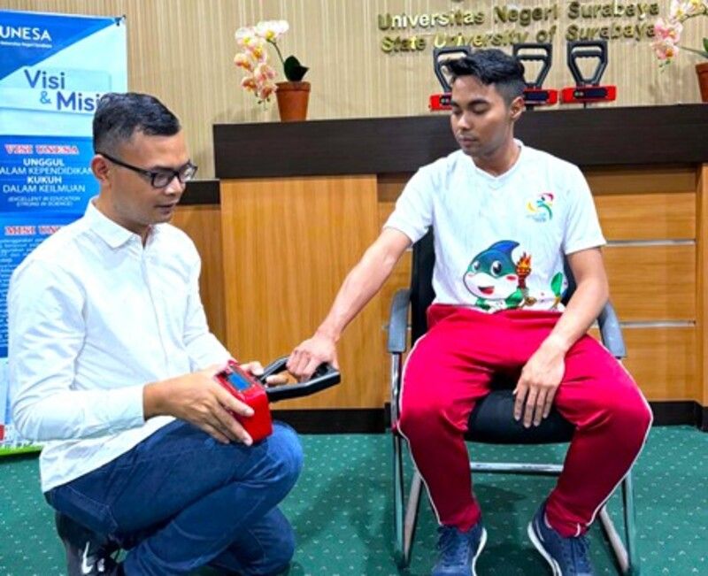 Ketua tim peneliti sekaligus dosen Fakultas Ilmu Keolahragaan dan Kesehatan (FIKK) Unesa, Muchamad Arif Al Ardha memperagakan cara menggunakan Hand-Held Dynamometer (Handem). 