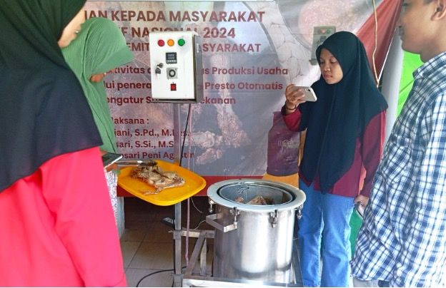 Didampingi tim dosen UNESA, pelaku usaha langsung belajar menggunakan inovasi mesin presto otomatis. 