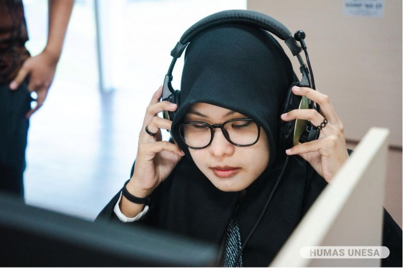 SEMANGAT-PENUH HARAP: Abidah Ardelia peserta tunanetra asal Sidoarjo tampak antusias mengikuti UTBK di Unesa. Ia mengenakan alat â��pembaca soalâ�� teks menjadi audio. 