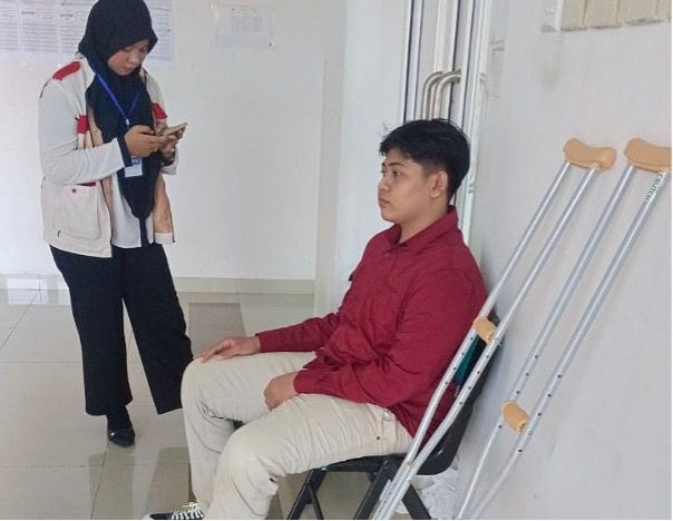 Didampingi panitia, Zeica menunggu giliran tes dengan tongkat kaki atau kruk di sampingnya. Kondisinya masih masa pemulihan usia operasi, akibat patah tulang karena kecelakaan sepulang sekolah.